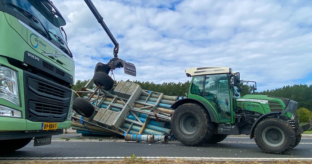 Aanhanger met lading buizen kantelt op rotonde in Leiderdorp