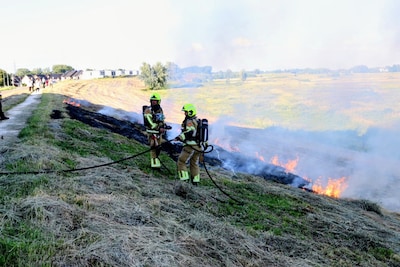 Brandweer blust bermbrand langs Echteldsedijk in Tiel