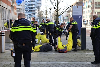 Politie draagt demonstranten Extinction Rebellion weg die voor dood spelen bij Ministerie van Klimaa