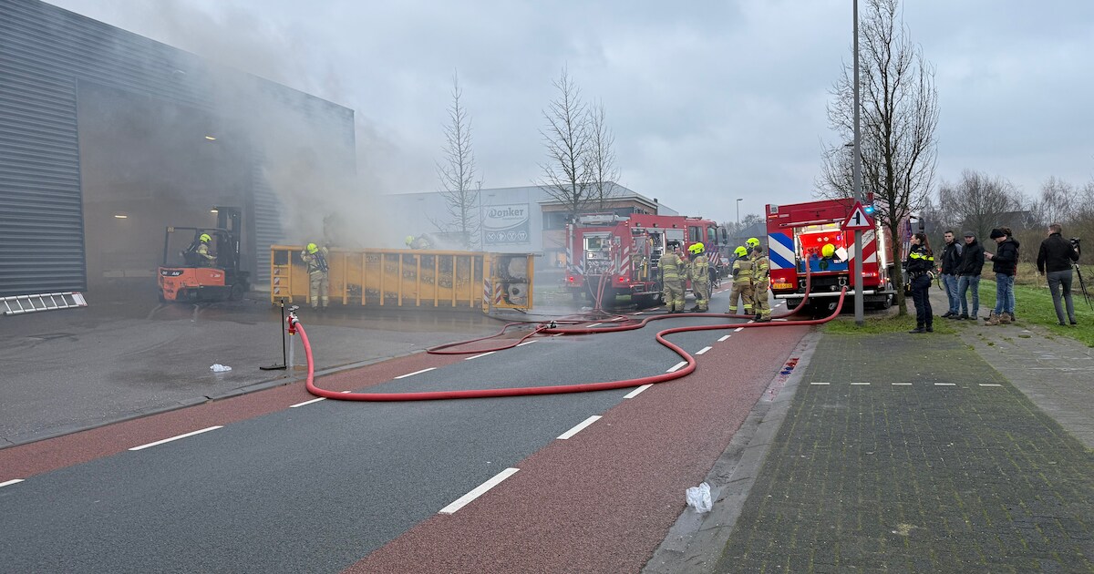 Inhoud van bouwcontainer vat vlam in bedrijfspand aan De Spil in Kootwijkerbroek
