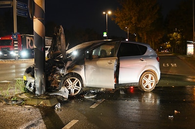 Auto vliegt in brand na botsing tegen paal op kruising in Breda: vrouw (65) naar het ziekenhuis