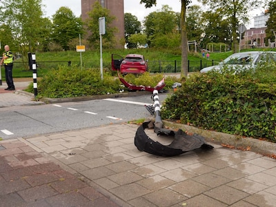 Auto rijdt verkeerslicht omver en komt aan andere kant van de weg tegen hek tot stilstand in Helmond