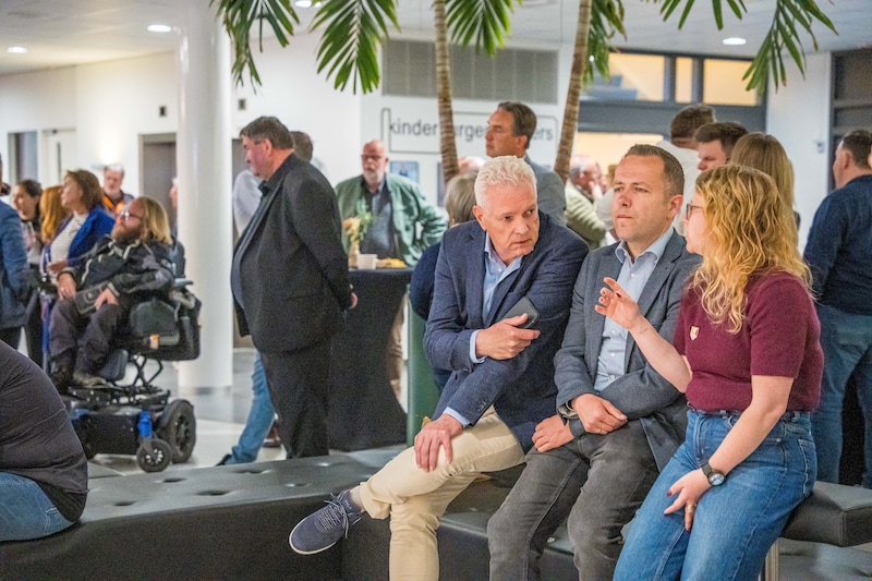 Raadsleden, onder wie Niels van Santen (tweede van links) en Paulien de Groot (rechts), wachten op de uitslag.