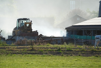Brand breekt uit naast stal bij boerderij in Oosteind, boer grijpt in met shovel