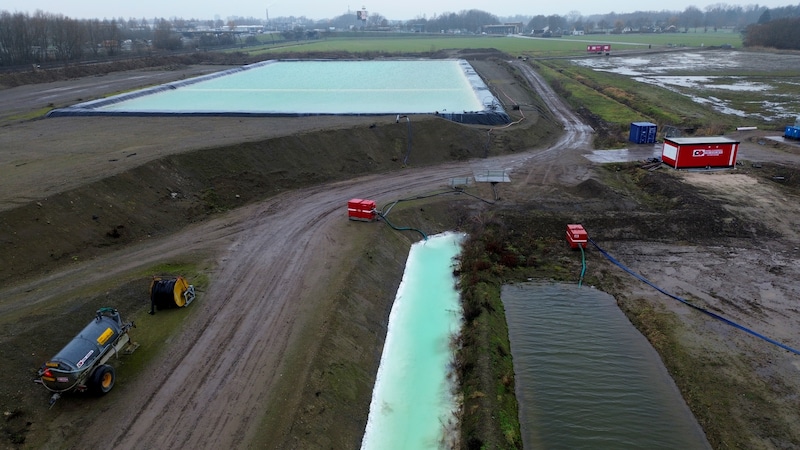 Het staalslakkendepot op de achtergrond. Het water op de voorgrond (links) is verontreinigd, maar wordt met pompen naar een filterinstallatie gebracht voor reiniging. 