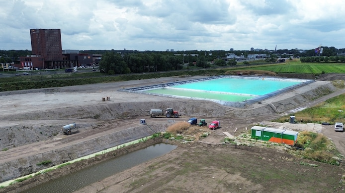 Het terrein met het staalslakkendepot: tractoren met watertanks moeten voorkomen dat er stof ontstaat. Op de achtergrond is Gorinchem te zien met onder meer het Van der Valk hotel.  