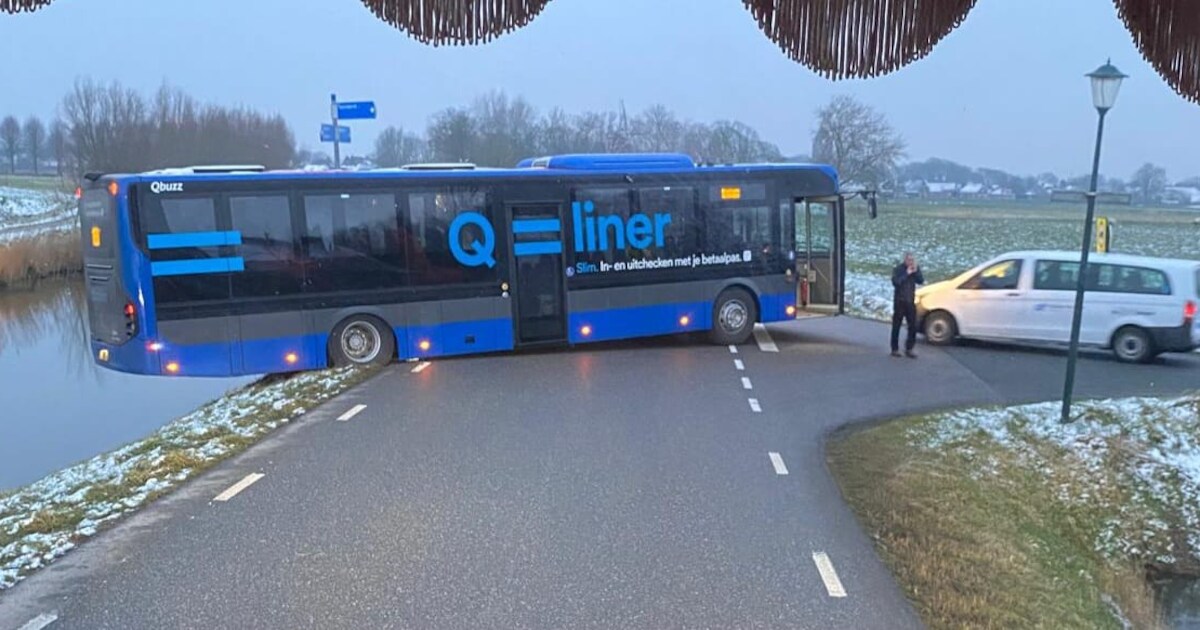 Lijnbus raakt van weg en hangt met achterkant boven Gronings kanaal