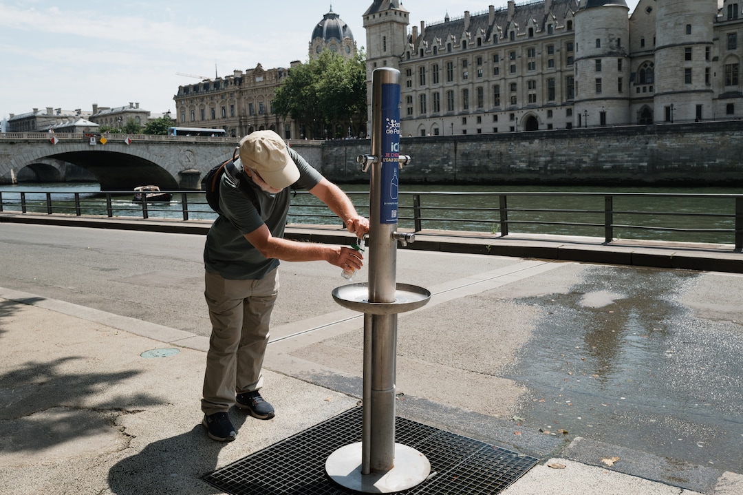 een-man-vult-een-waterflesje-in-parijs
