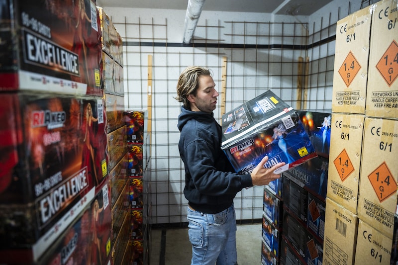Een verkoper laat het vuurwerk in zijn opslag zien.