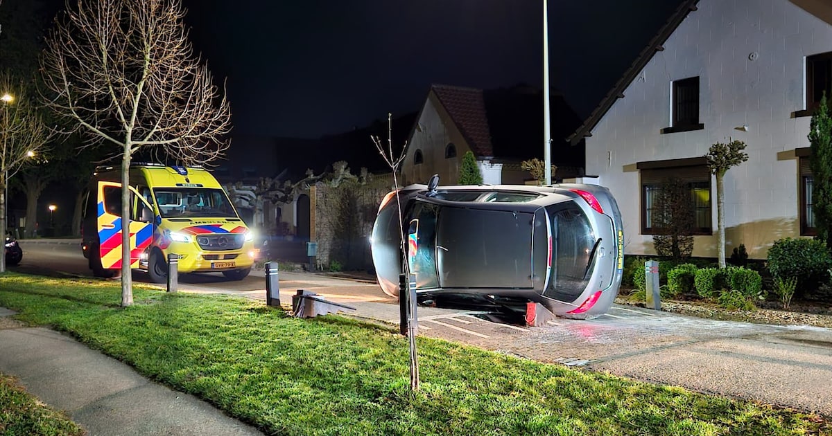 Auto op zijn kant op de Maasstraat in Herten