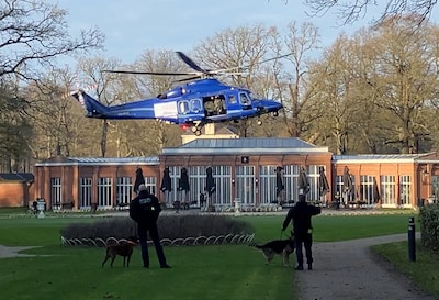 Een felblauwe Zulu landt in de Franse tuin van landgoed Mattemburgh, twee agenten in donkere kleding