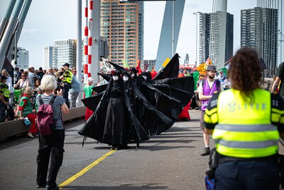 Protestmars op Erasmusbrug tijdens Wereldhavendagen: activisten gekleed in rode en zwarte outfits