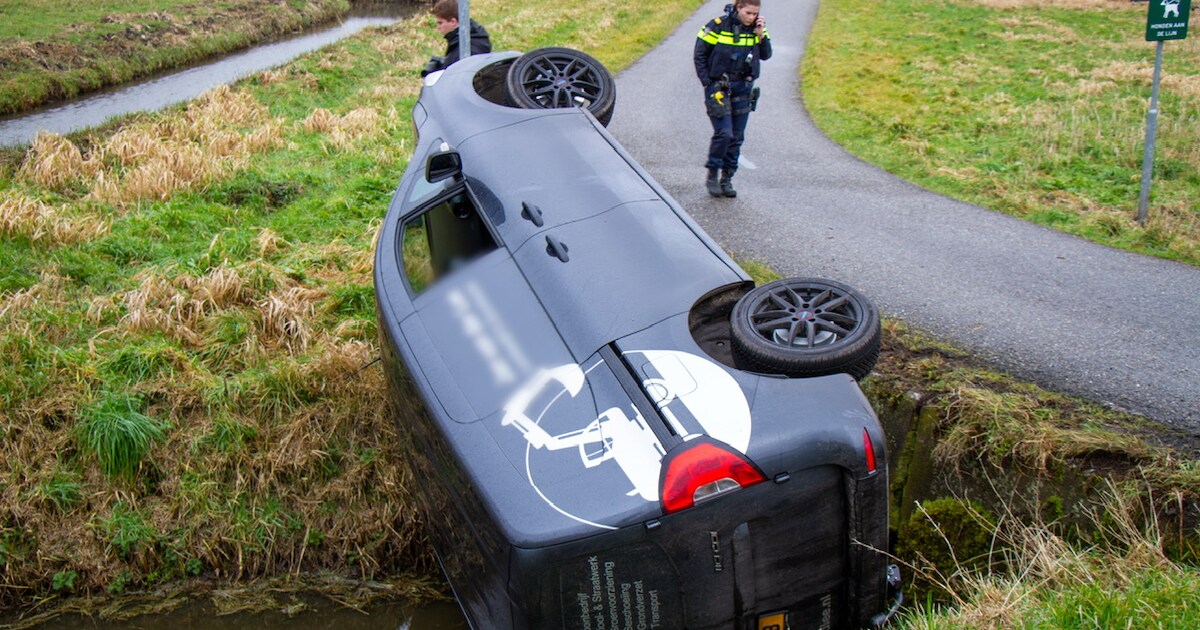 Chauffeur bedrijfsbus rijdt sloot in op Lagedijk in Spaarndam