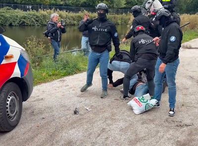 Politie duwt fotograaf in water bij rellen Malieveld